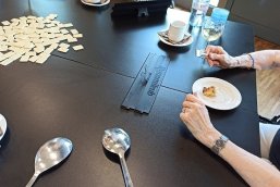 Rummy-Cub und eine leckere Überaschung beim Spieltreff Man sieht Spielsteine und eine Person beim Kuchen essen
