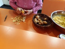 Döbbekuchen - Kochaktion im Plaudertreff der Auschnitt zeigt eine Frau, die Kartoffeln schält