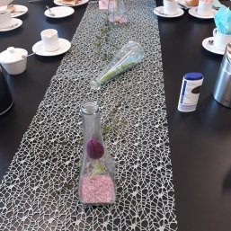 Dekorationsbeispiel Ein Tischläufer mit liegender Flasche auf einem schwarzen Tisch