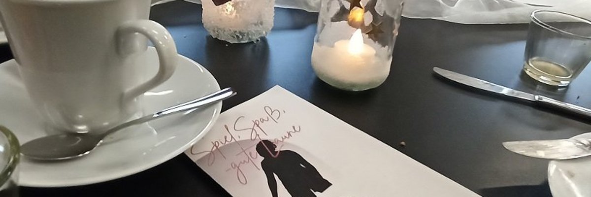 Man sieht ein Faltblatt auf dem Frühstückstisch liegen.