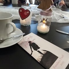 Man sieht ein Faltblatt auf dem Frühstückstisch liegen.