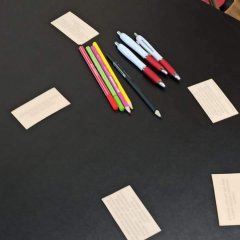 Auf dem Foto ist ein Tisch mit Stiften und Papier zu sehen