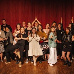 Die Gruppe steht in verschiedenen Yoga-Positionen.