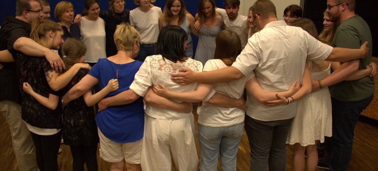 Die Theatergruppe steht sich umarmend im Kreis.