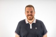 Nicholas Duhr Junger Mann mit Bart und blau-weißem Polo Shirt lächelt in die Kamera